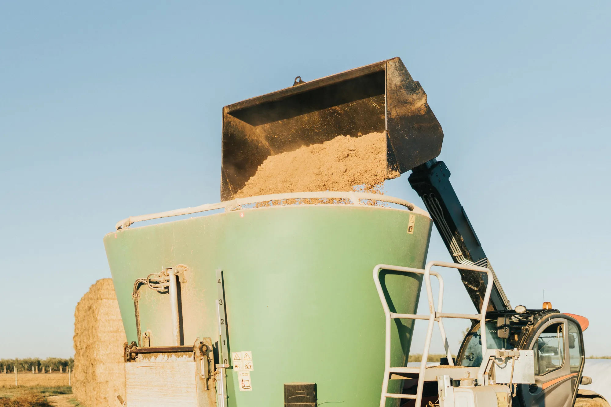 Merxally a-tractor-tipping-animal-feed-inside-container-image